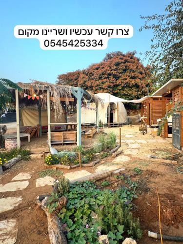 a garden with plants and tents in a yard at חוות רפאל - פרדס חנה in Mashabbe Sade