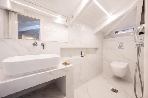 een witte badkamer met een wastafel en een toilet bij Spiros Family Apts in Laganas