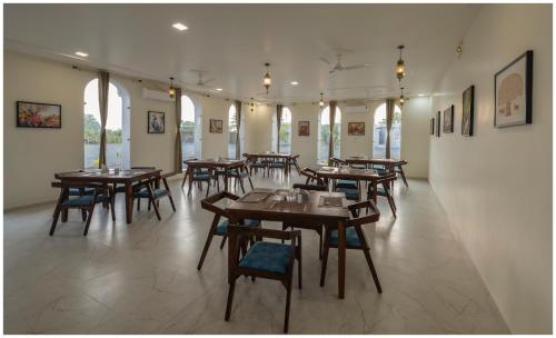 a restaurant with wooden tables and chairs in a room at Upvan Jawai - Unit of Dev Group in Bāli