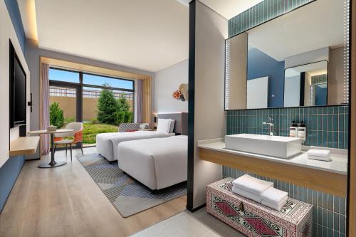 a bathroom with a sink and a living room at Holiday Inn Express Nalati By IHG in Narat