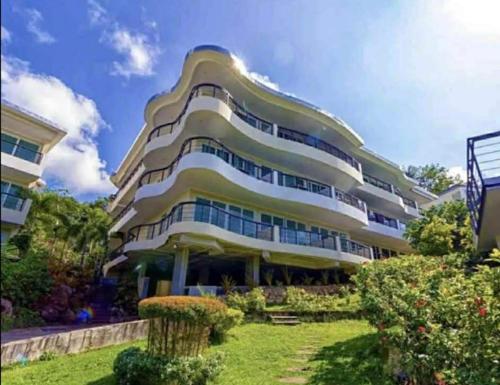 a large apartment building with a garden in front of it at Karon Butterfly Phuket in Ban Karon