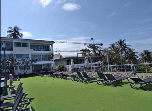 a group of chairs sitting on a lawn in front of a building at Karon Butterfly Phuket in Ban Karon