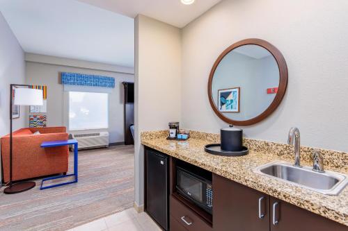 帕克斯堡汉普顿帕克市中心酒店（Hampton Inn and Suites Parkersburg Downtown）的浴室里有洗手池和镜子