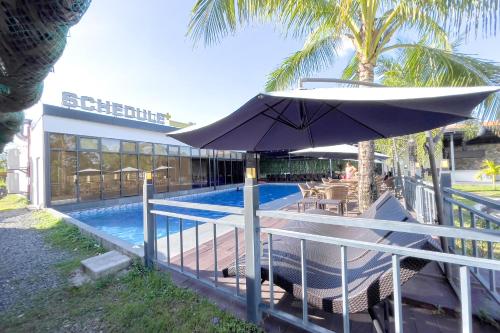 クラークにあるOlle Hotel Clark City powered by Cocotelの隣のスイミングプール(傘付)