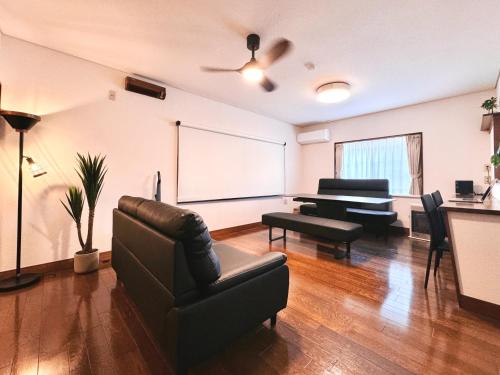 a living room with a couch and a piano at 塩釜バケーションレンタルKiten in Shiogama