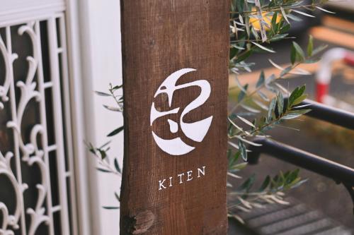 ein Schild an einem Holzpfahl vor einem Tor in der Unterkunft 塩釜バケーションレンタルKiten in Shiogama