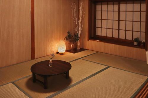 a room with a table and a lamp on the floor at 塩釜バケーションレンタルKiten in Shiogama