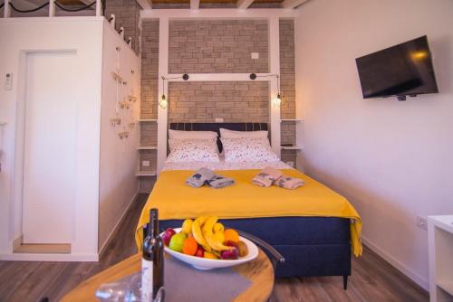 a bedroom with a bed with a bowl of fruit on a table at Andrej studio A2 in Veli Lošinj