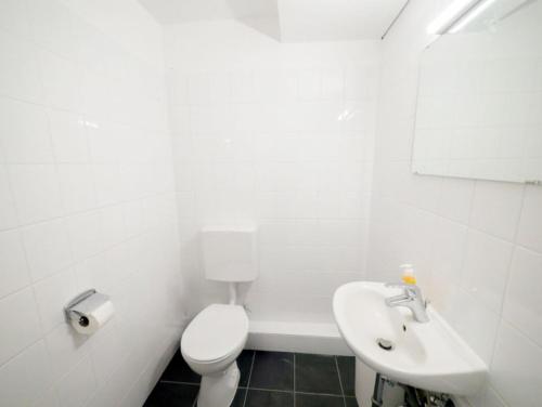 Un baño blanco con inodoro y lavabo. en Apartment im Zentrum von Ahrensburg, en Ahrensburg