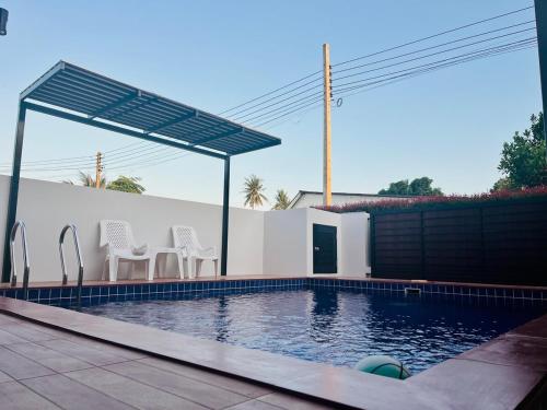a swimming pool with two chairs and a canopy over it at Pooky Pool Villa Aonang in Ban Nong Chaeng