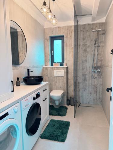 a bathroom with a sink and a washing machine at SweetNest in Gurahonţ