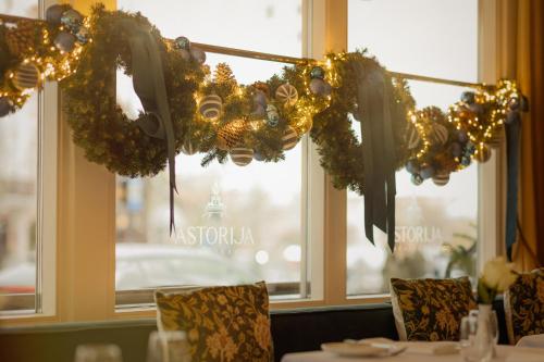 una sala da pranzo con un tavolo con ghirlande sulla finestra di Radisson Collection Astorija Hotel, Vilnius a Vilnius