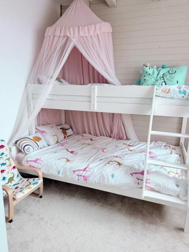 a bedroom with two bunk beds and a chair at SweetNest in Gurahonţ
