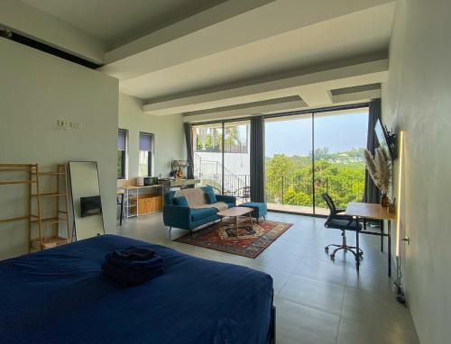 a bedroom with a blue bed and a living room at Kanchaya Residence Apartment in Ko Ma