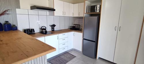 una cucina con mobili bianchi e un frigorifero nero di Bella Vanti Views Self Catering a West Point