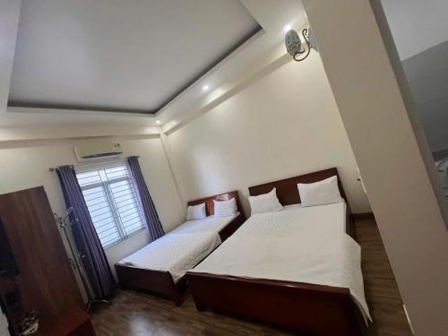 a bedroom with two beds and a window at Bảo Anh Motel in Hải Dương