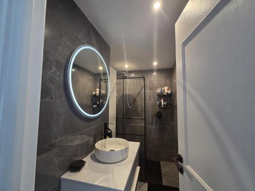 ein Badezimmer mit Waschbecken und Spiegel in der Unterkunft Joli 4 pièces - Terrasse vue mer - Parking - FC in Saint-Laurent-du-Var