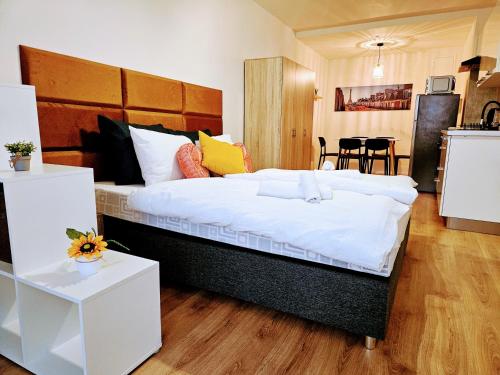 ein Schlafzimmer mit einem großen Bett mit weißer Bettwäsche in der Unterkunft LIVE-INN PRAGUE APARTMENTS for Business Trips, Families and Large Groups, Free Parking & Gym, Private Garden, Roof Terrace & Game Room in Prag
