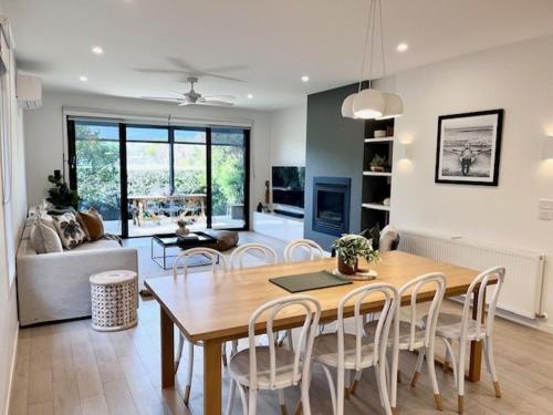 The Ebb Luxury Retreat - Just steps to the beach! في أوشن غروف: غرفة طعام وغرفة معيشة مع طاولة وكراسي