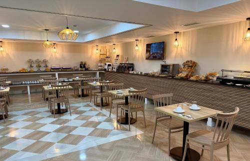 Un restaurante con mesas y sillas de madera y un mostrador. en Hotel Córdoba Centro, en Córdoba