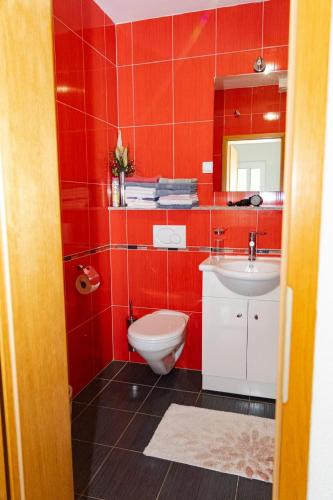 a red bathroom with a toilet and a sink at Nina in Split