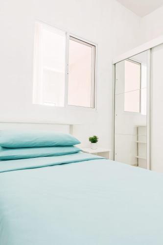 a white bedroom with a bed and a mirror at Doce Lar São Francisco in Cabo de Santo Agostinho