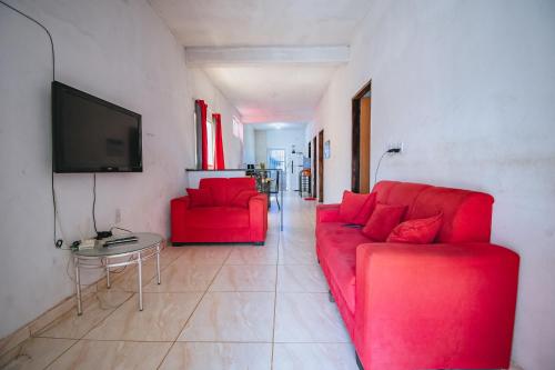 a living room with a red couch and a table at Doce Lar 58-Casa de Hóspedes in Cabo de Santo Agostinho
