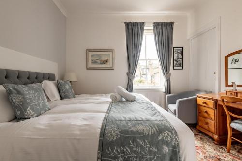 um quarto com uma cama, uma escrivaninha e uma janela em Market Street No 28a - St Andrews em St Andrews