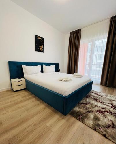 a bedroom with a bed and a large window at Real Resort in Ploieşti