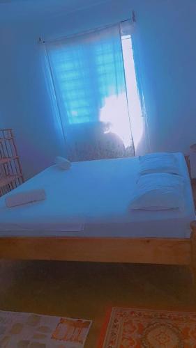 a bed in a room with a blue light at HIGSAM apartment in Diani Beach