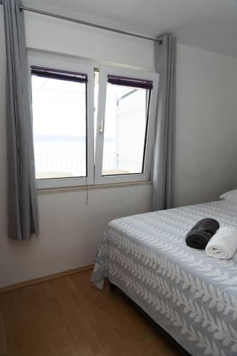 a bedroom with a bed and two windows at Nina in Split