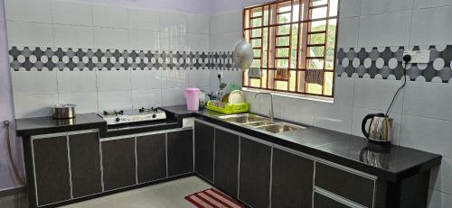 a small kitchen with a sink and a window at Liya's Homestay in Kangar