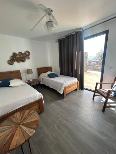 a bedroom with two beds and a sliding glass door at Villa Groovy in Lajares