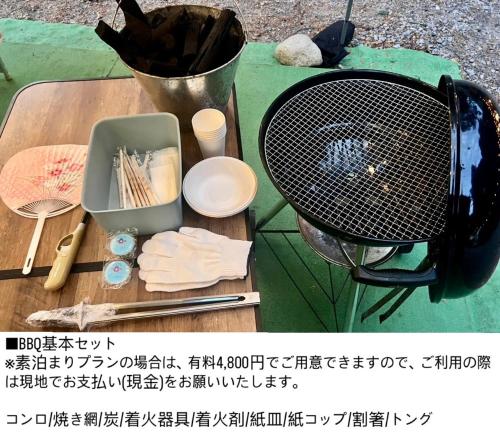 a table with a grill and some utensils on it at リバーサイドグランピングNuts in Higashiomi
