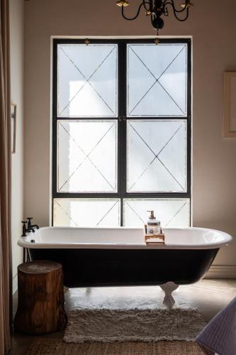 a bath tub sitting in front of a window at Hemyock Farm Moon Cottage in Nottingham Road