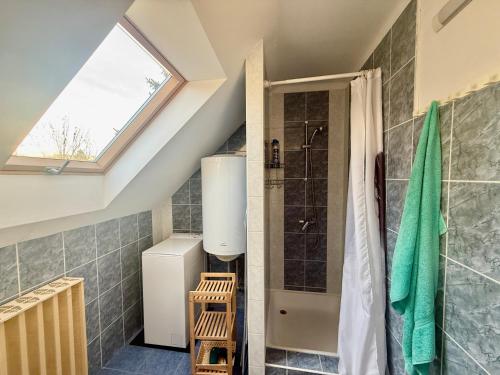 a attic bathroom with a shower and a window at Chill & Pool Retreat Almádi in Balatonalmádi