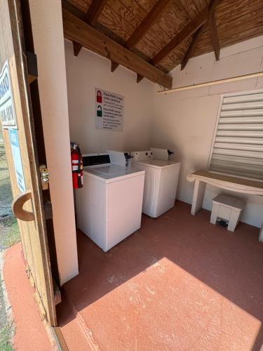 a room with two white tables and a bench at Condo Ocean View from Balcony Swimming Pool Playa Sucia in Cabo Rojo