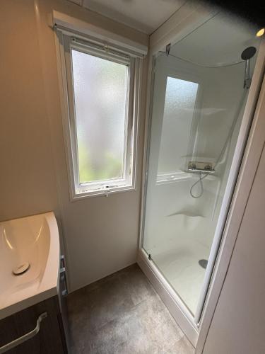 a bathroom with a shower and a sink and a window at Luxe 6 persoons Chalet camping Leï Suves Cote d'Azur Roquebrune-sur argens in Roquebrune-sur-Argens