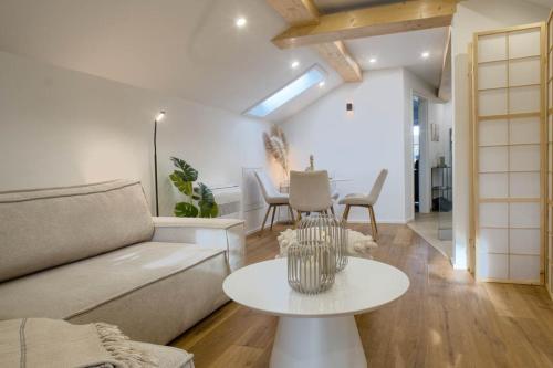 a living room with a couch and a table at Alpenloft mit Garten & BBQ am Chiemsee by Dollop Living in Bernau am Chiemsee