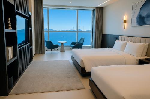 Una habitación de hotel con dos camas y vista al mar. en WAVEM HOTEL East, en Siheung