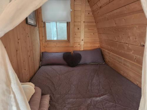 ein kleines Zimmer mit einem Bett in einem Blockhaus in der Unterkunft Cabana Exotique Piscine et Jacuzzi in Porto-Vecchio