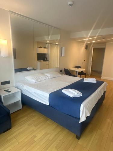 um quarto com uma cama grande com um cobertor azul em Orbi city premium plus em Itʼkhvisi