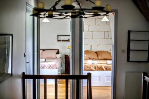 a bedroom with a reflection of a bed in a mirror at Gîte Gué Léger - Nature & Spa - Jacuzzi, Sauna - Piscine chauffée toute l'année - 15 pers in Chanceaux-près-Loches