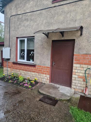 a house with a brown door and a window at Brīvdienu māja Vecdaugavā in Rīga