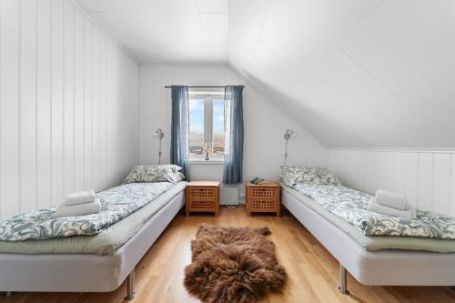 En eller flere senge i et værelse på Stornes Gård Guesthouse