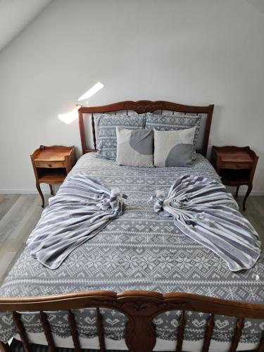 a bed with a wooden headboard and pillows at Casă mică și șarmantă la țară in Plonévez-du-Faou