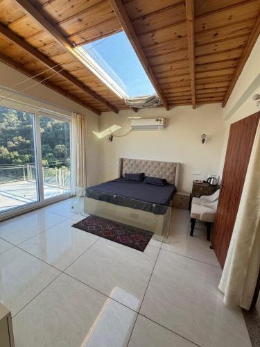 a bedroom with a bed and a large window at Shail by Shubhs in Bhowāli
