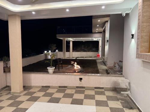 a living room with a checkered floor and a fireplace at Shail by Shubhs in Bhowāli