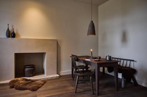 a dining room with a table and a fireplace at The Coach House Lodges at Denton Reserve in Denton
