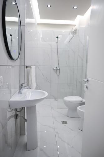 a white bathroom with a sink and a toilet at The Minimalist Escape in Kamëz